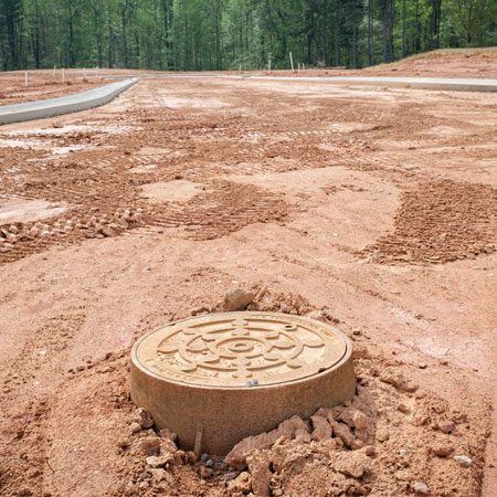 Commercial work services are underway on a commercial development with sewers, water mains and underground utilities installation maintenance covers.