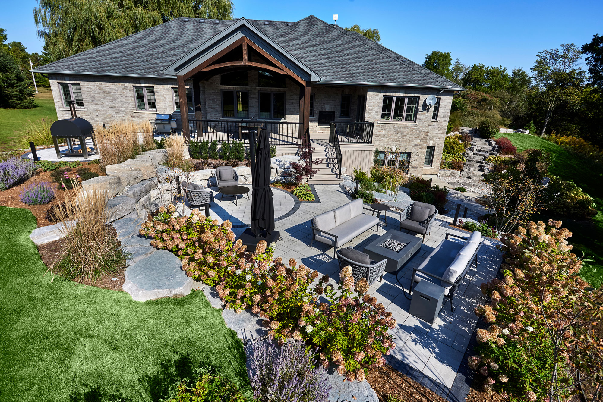 An entertainer’s backyard paradise with multitiered garden spaces created by landscape planning, residential excavation, grade elevation and armour stone.