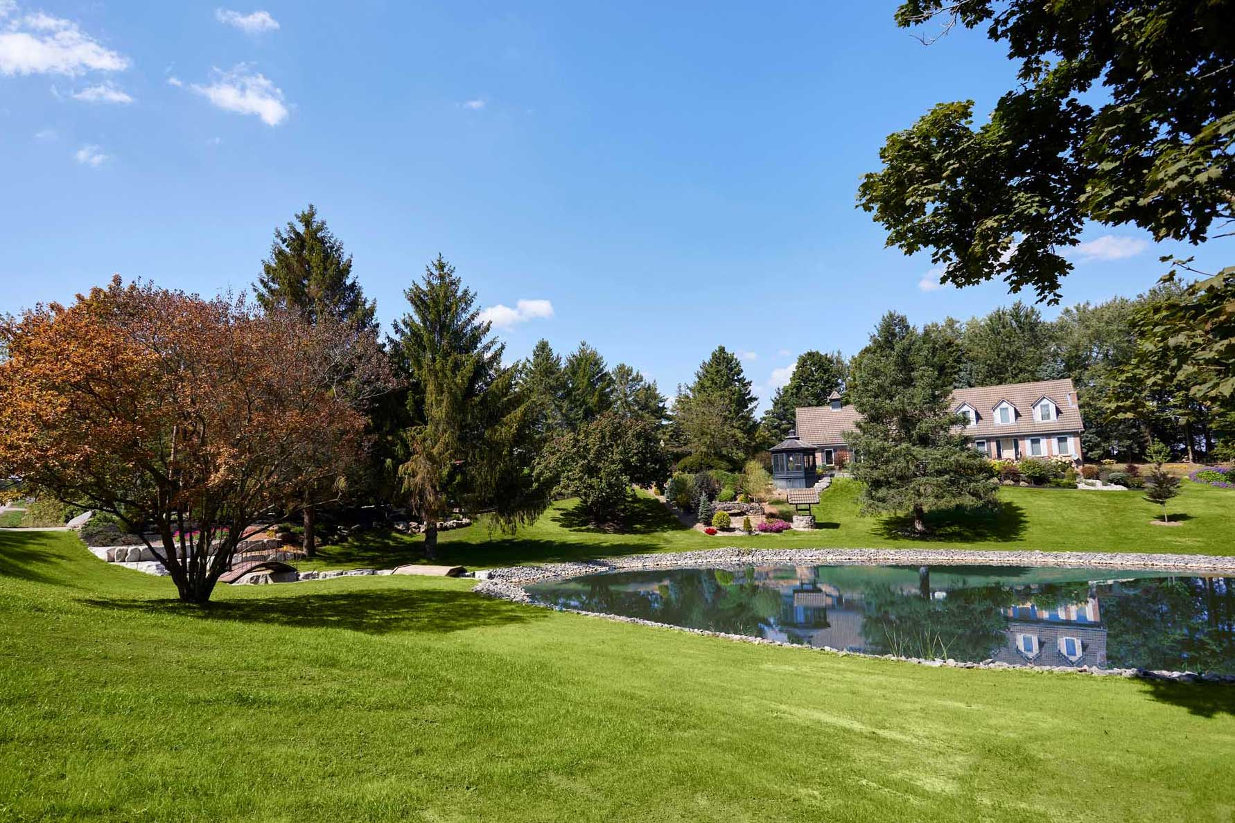 A well-groomed residential estate yard with a pond after excavation corrected flooding, grading and drainage problems.